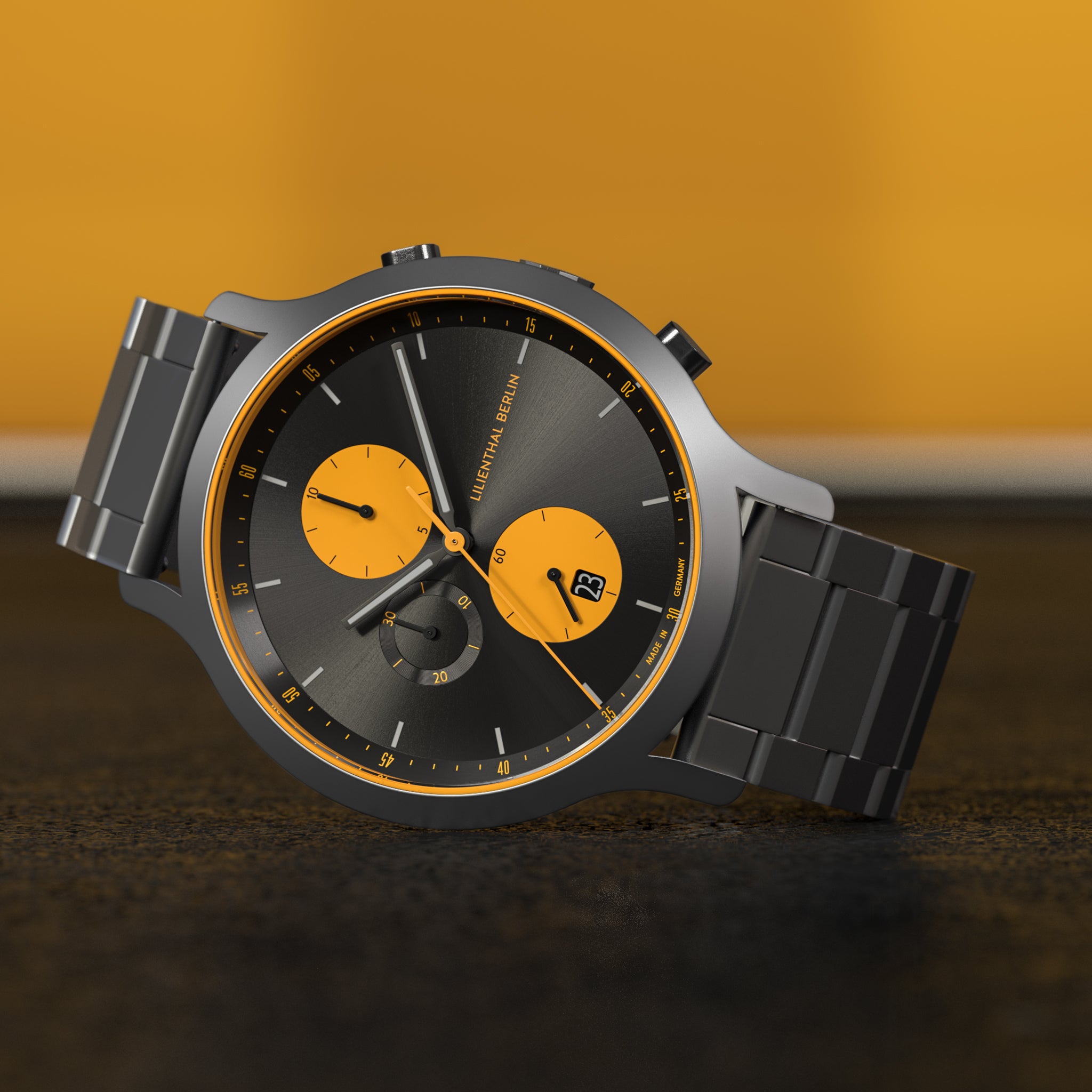 Black metal chronograph watch with yellow subdials and accents on black background