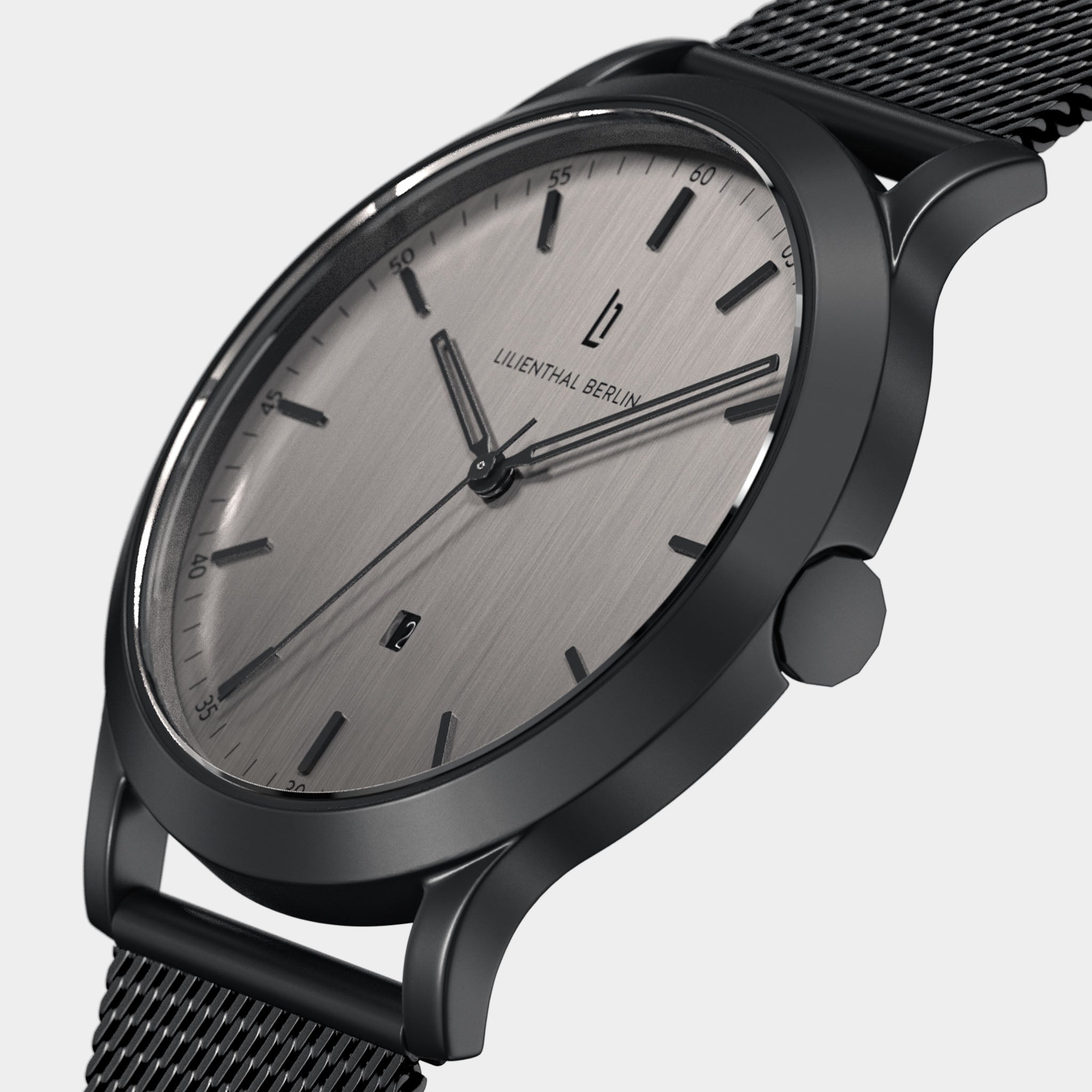 Minimalist stainless steel watch with brushed silver dial, mesh band, and black markers