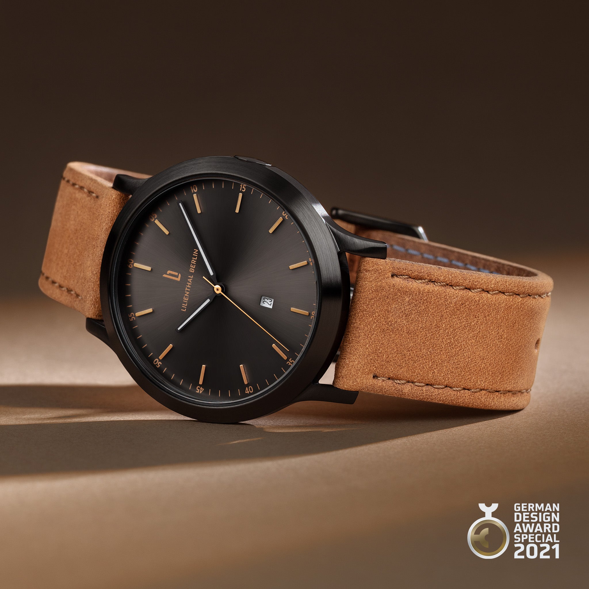 Minimalist black watch with brown leather strap, gold markers, and date display on beige background
