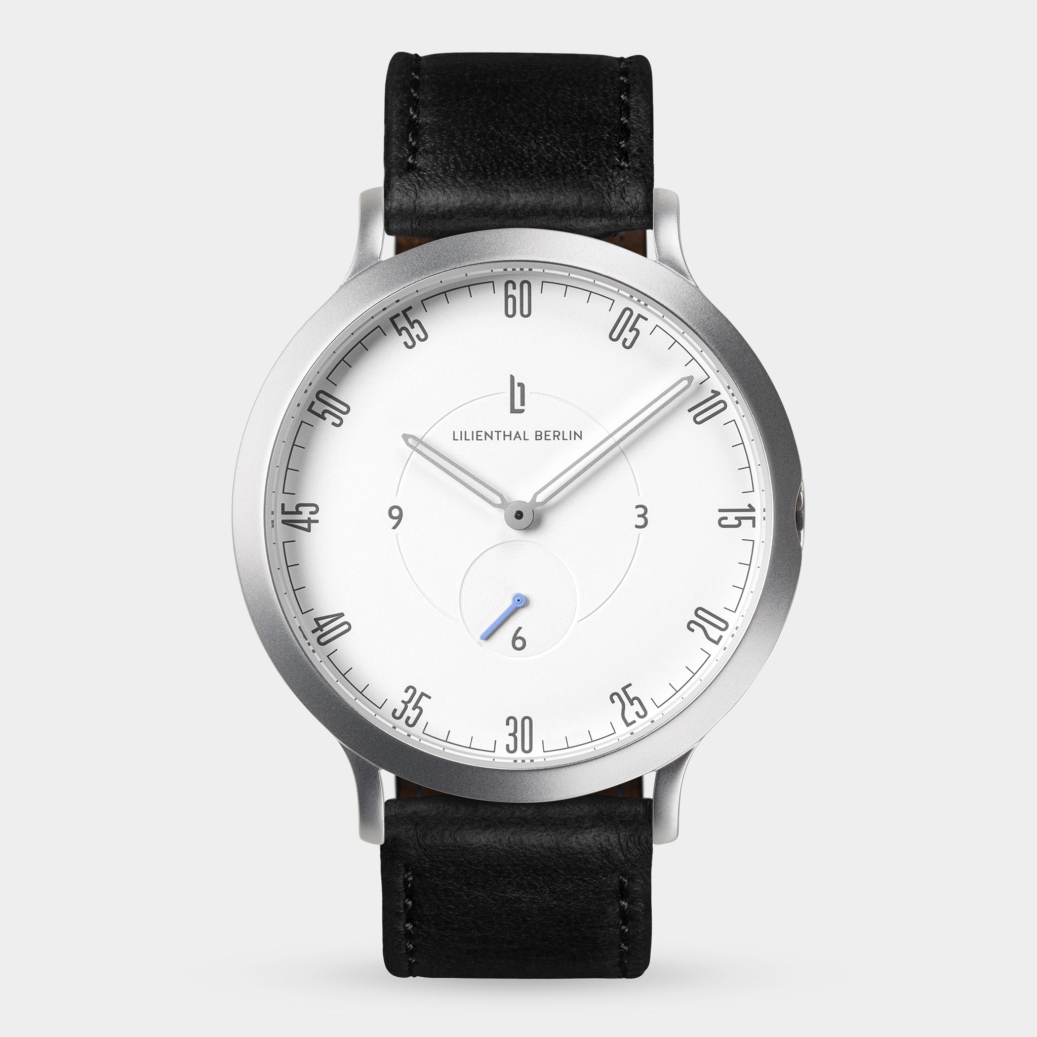 Minimalist wristwatch with silver case, white dial, black leather strap, and sleek markers