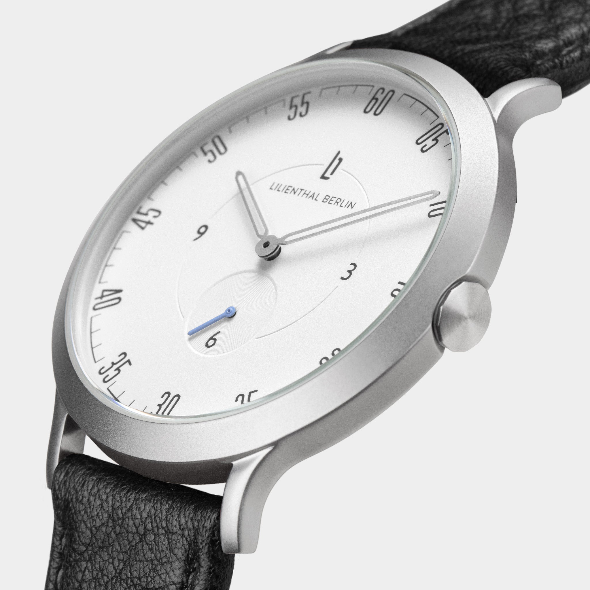 Minimalist silver analog watch with white dial, black leather strap, and blue second hand