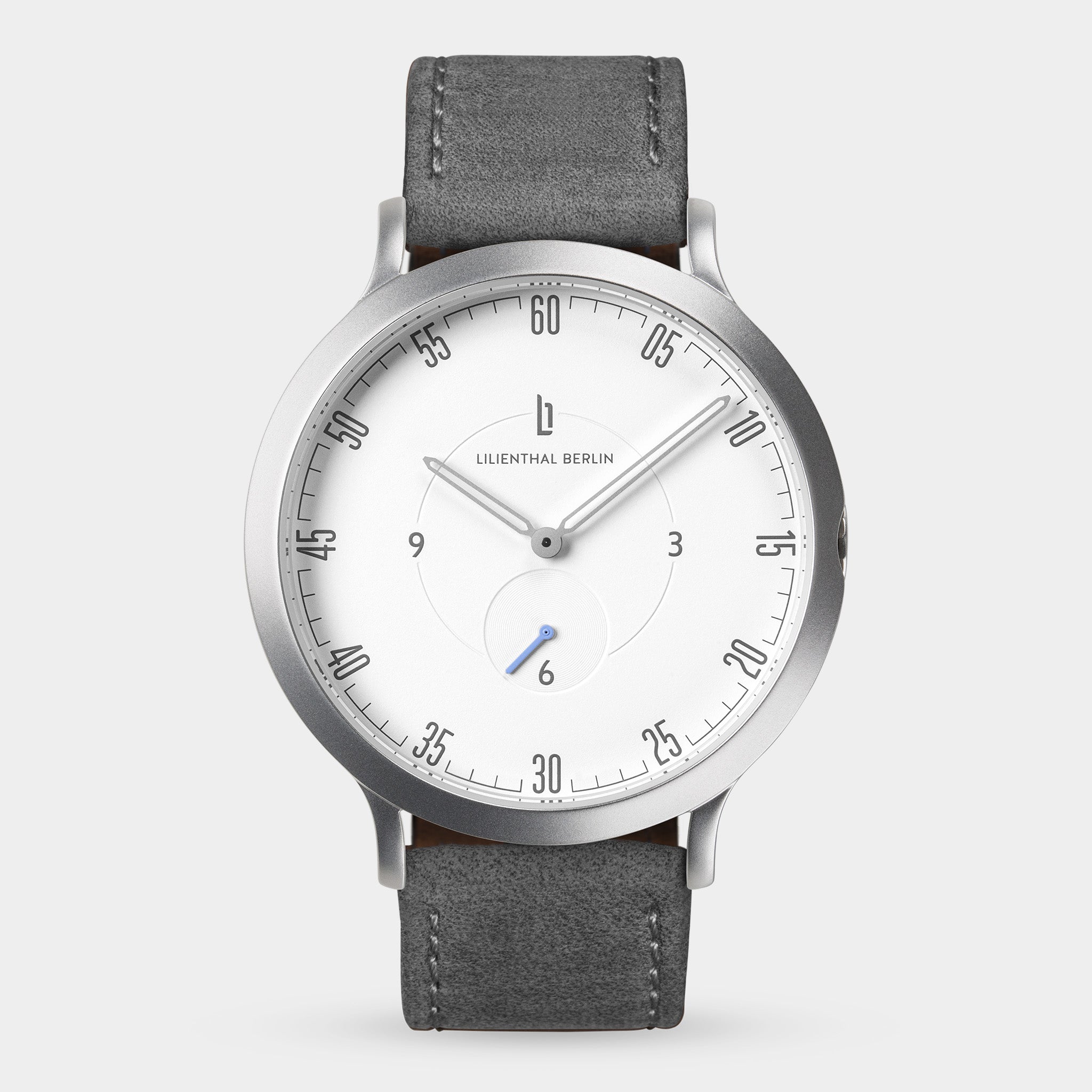 Minimalist silver wristwatch with white dial, black leather strap, and numbered minute markers.