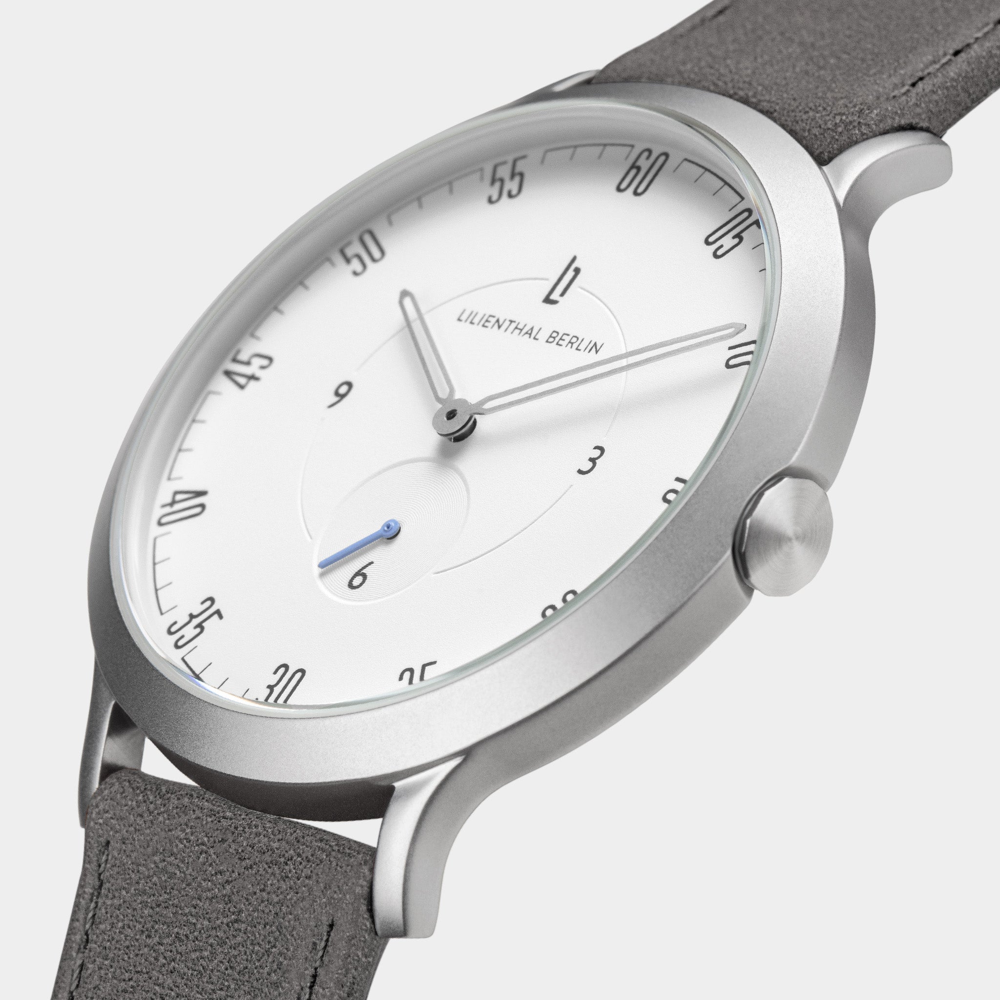 Minimalist silver watch with white dial, grey strap, and small blue seconds hand
