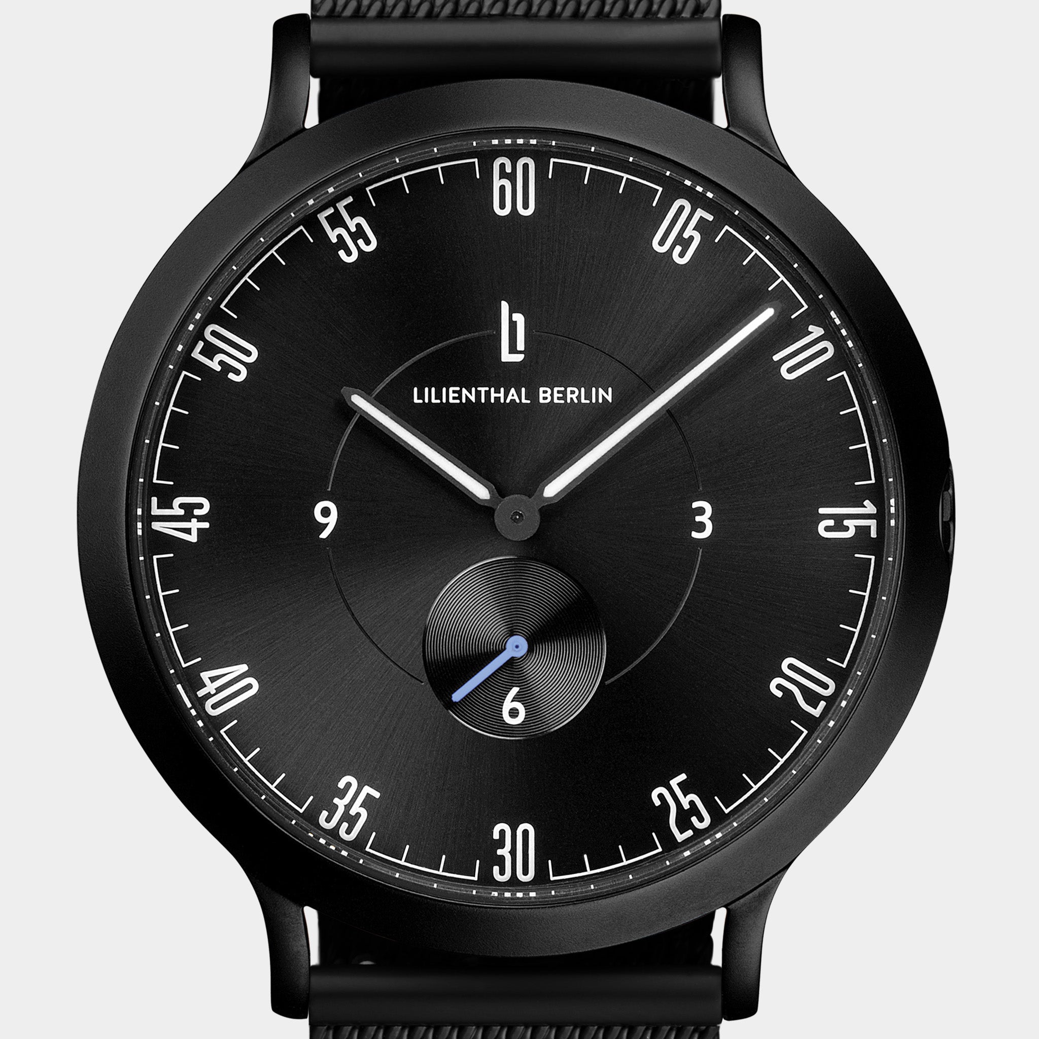 Minimalist black analog wristwatch with round dial, white markers, and sub-dial on face