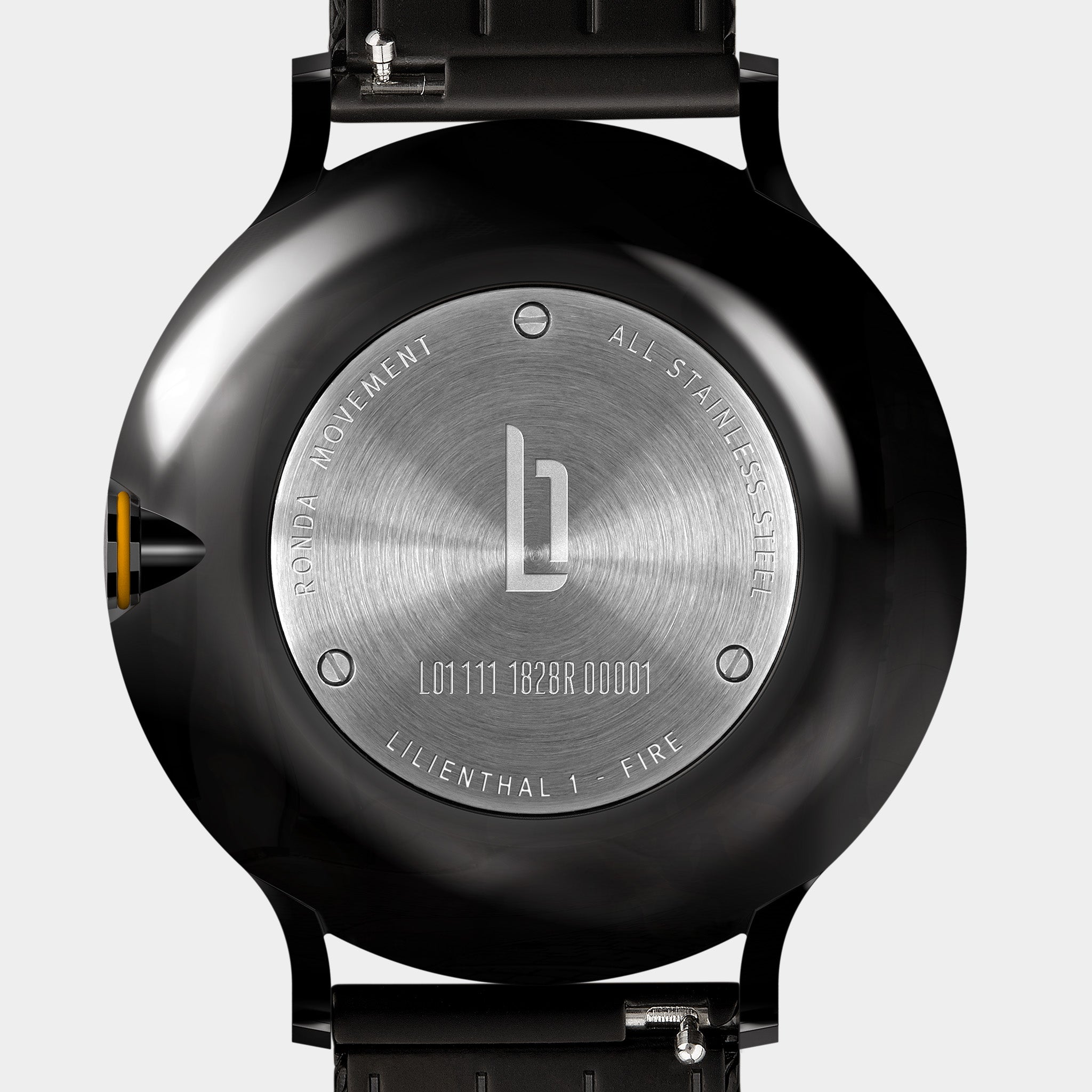 Close-up of stainless steel watch case back with engraved details and black strap