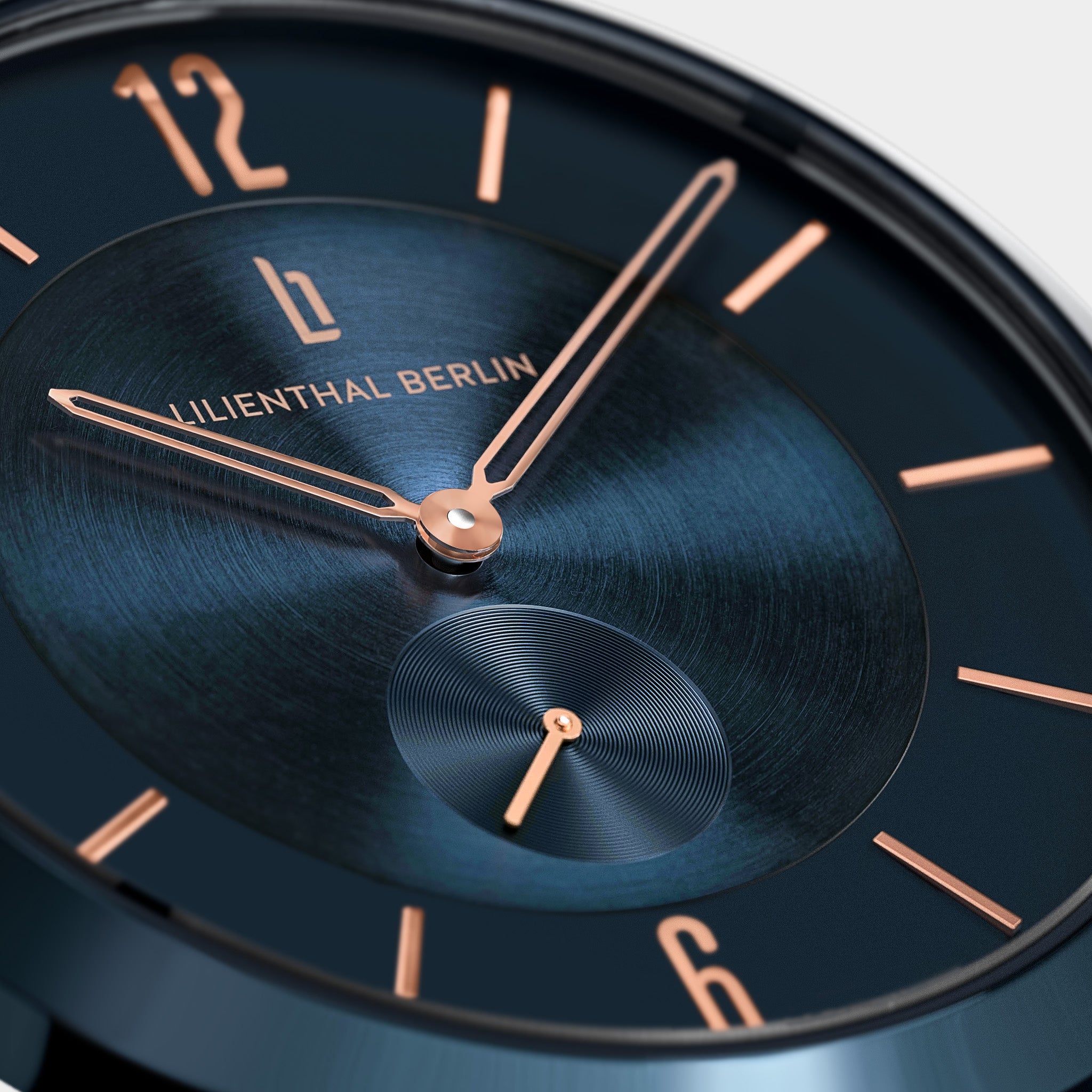 Close-up of modern dark blue watch face with rose gold hands and minimalist markers
