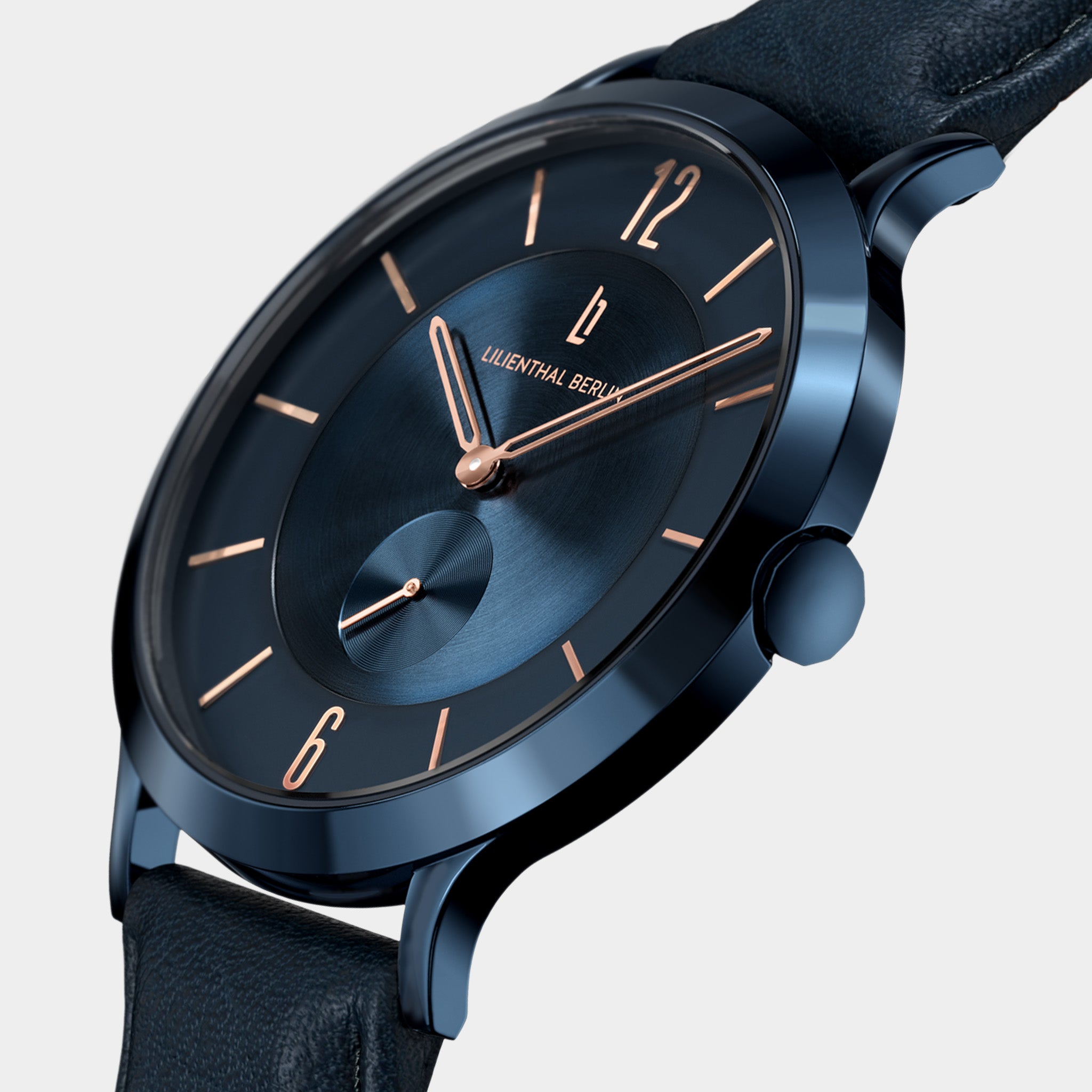 Close-up of a blue minimalist wristwatch with rose gold markers and a leather strap