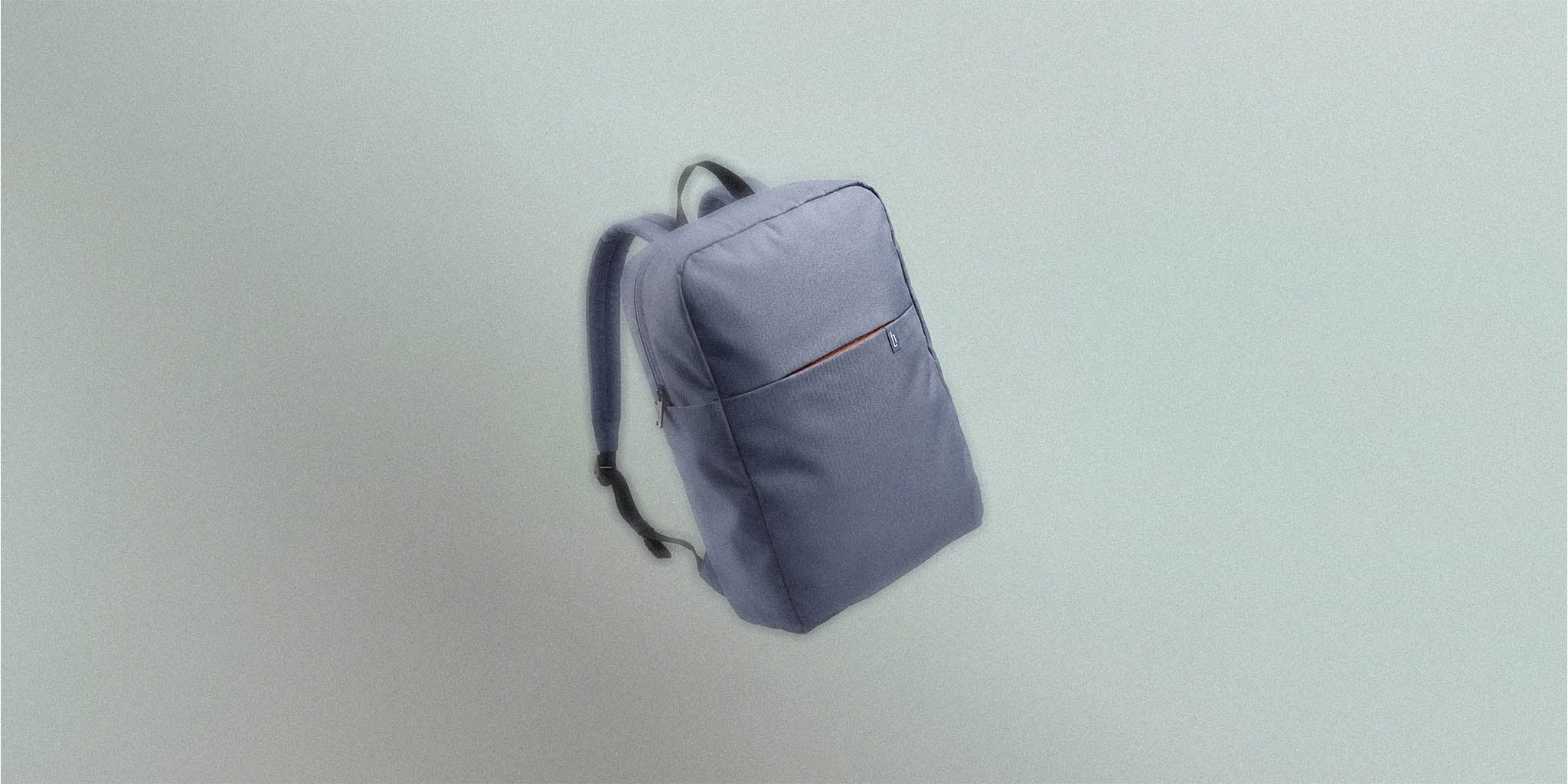 Minimalist grey backpack with front pocket and padded shoulder straps on neutral background