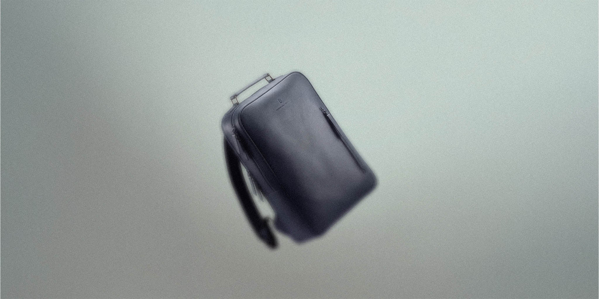 Minimalist black backpack with a sleek, modern design against a neutral background