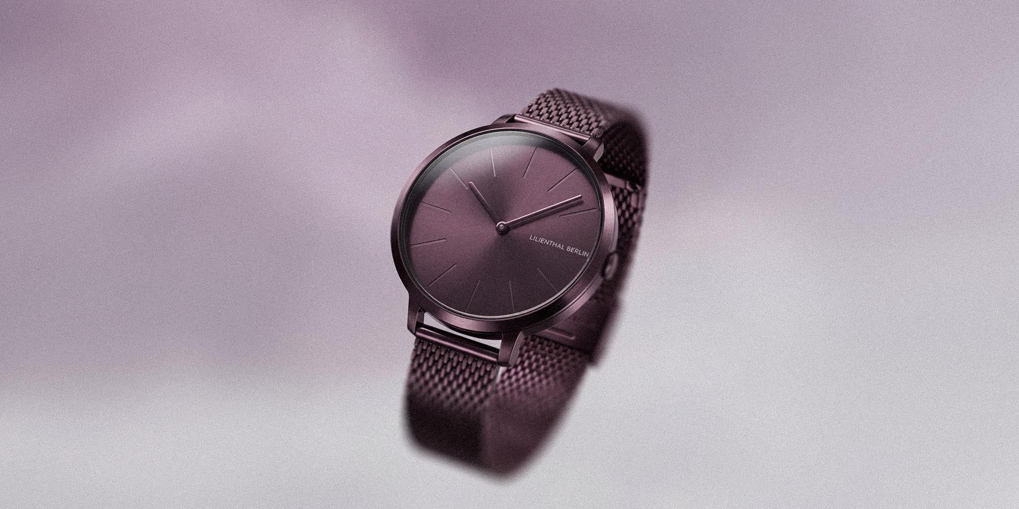 Minimalist purple mesh strap watch with clean dial on soft gradient background