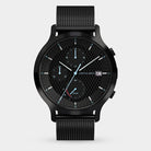 Black solar-powered chronograph watch with mesh strap, checkerboard dial, date display