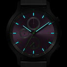 Chronograph watch with luminous blue hands and markers on a dark purple dial