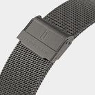 Close-up of a stainless steel mesh watch strap with clasp and engraved branding