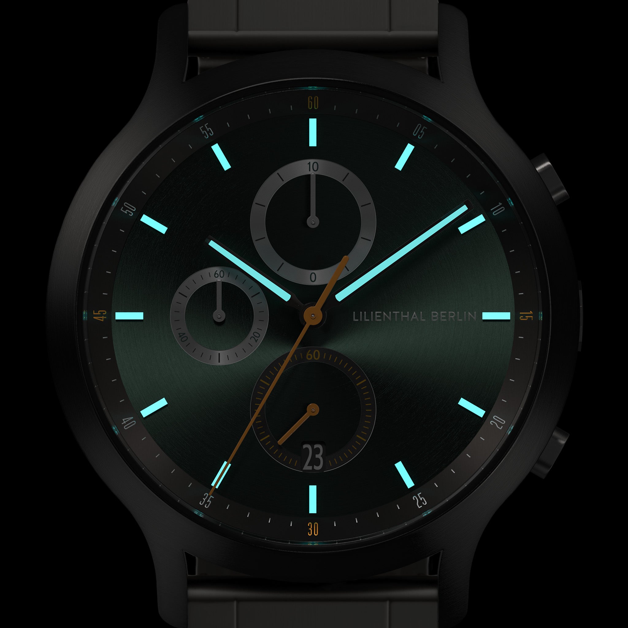 Close-up of modern black chronograph watch face with glowing turquoise markers and subdials.