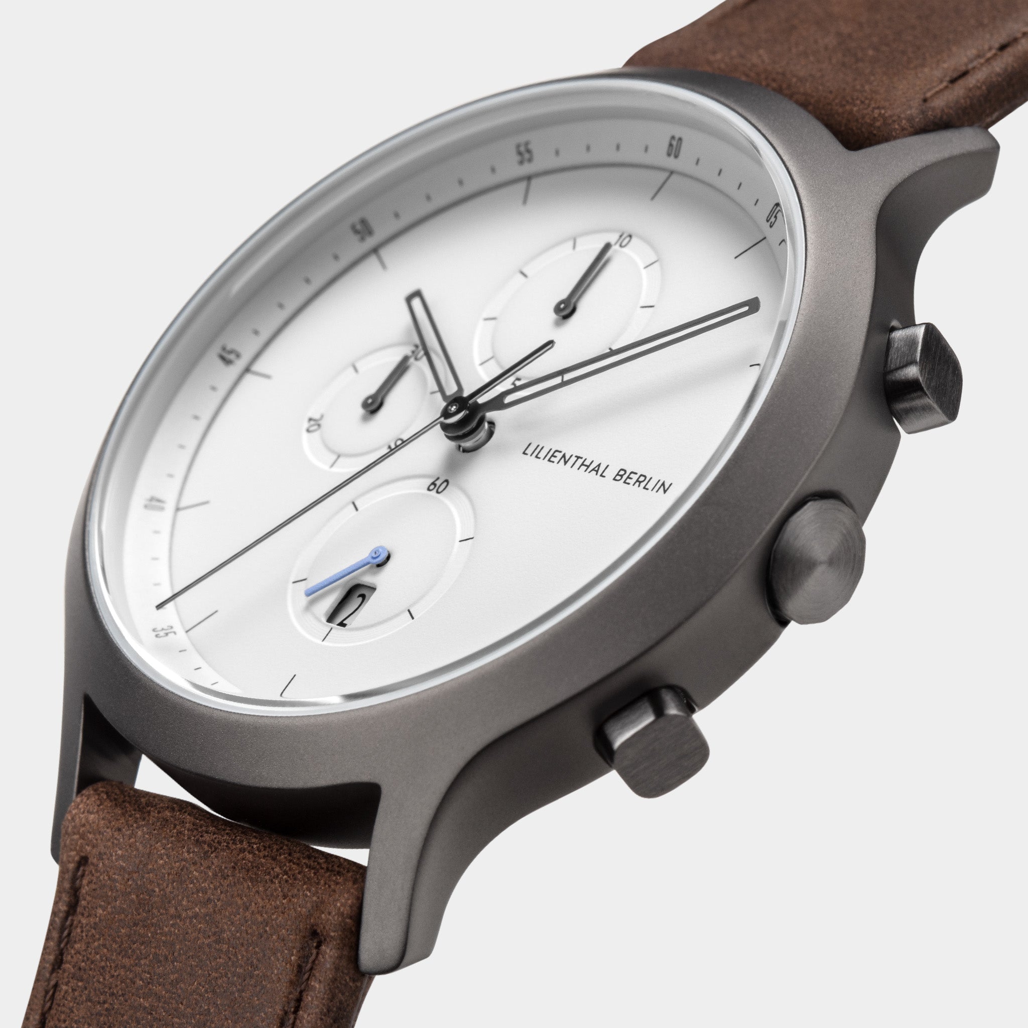 Minimalist chronograph watch with white dial, brown leather strap, and stainless steel case
