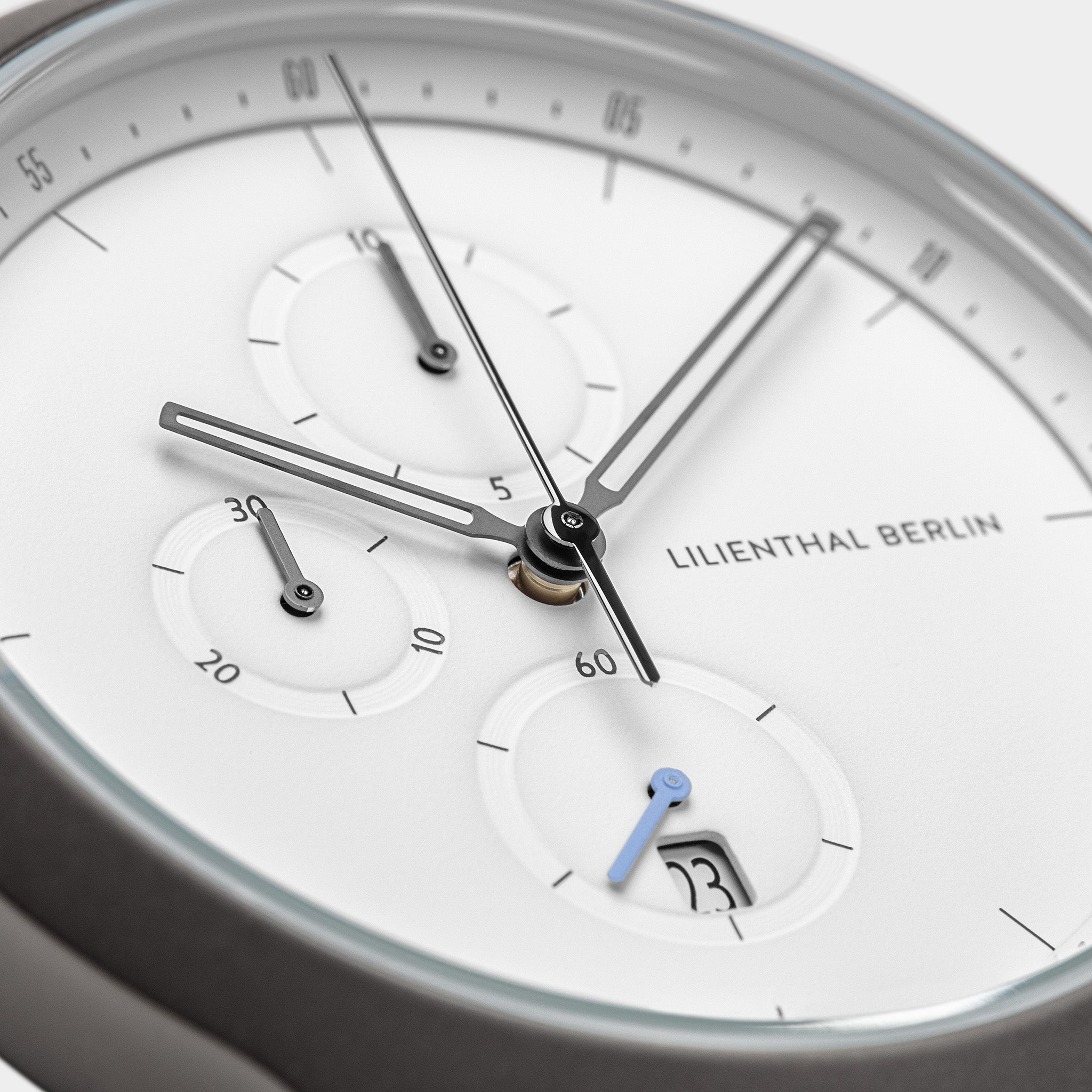 Minimalist chronograph watch face with subdials, white dial, sleek hands, visible date window