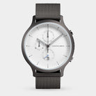 Minimalist chronograph watch with white dial, black mesh band, and date display