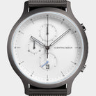 Minimalist chronograph watch with white dial, three subdials, date display, and mesh strap.