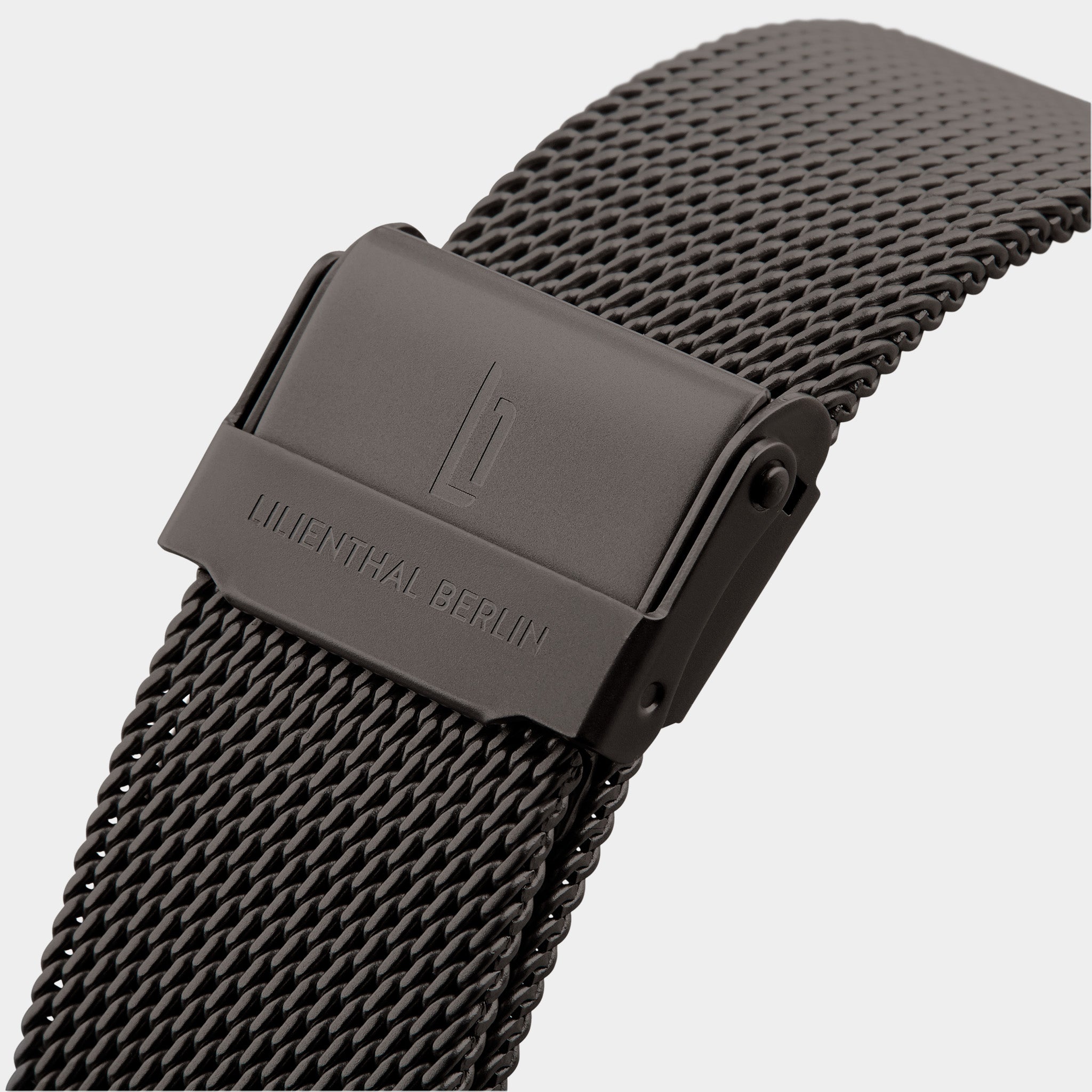 Black mesh stainless steel watch strap with clasp and engraved logo on white background