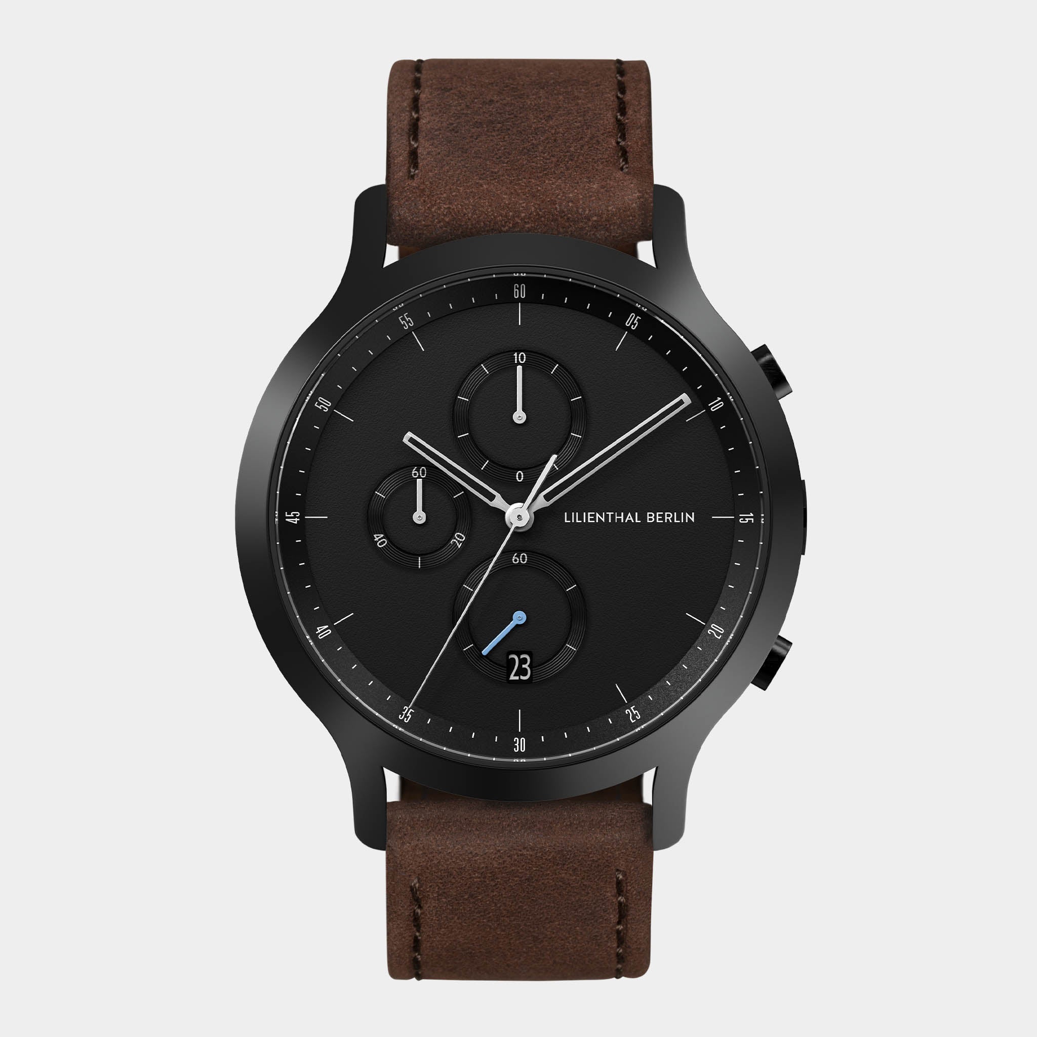 Black chronograph watch with brown leather strap and date display on white background