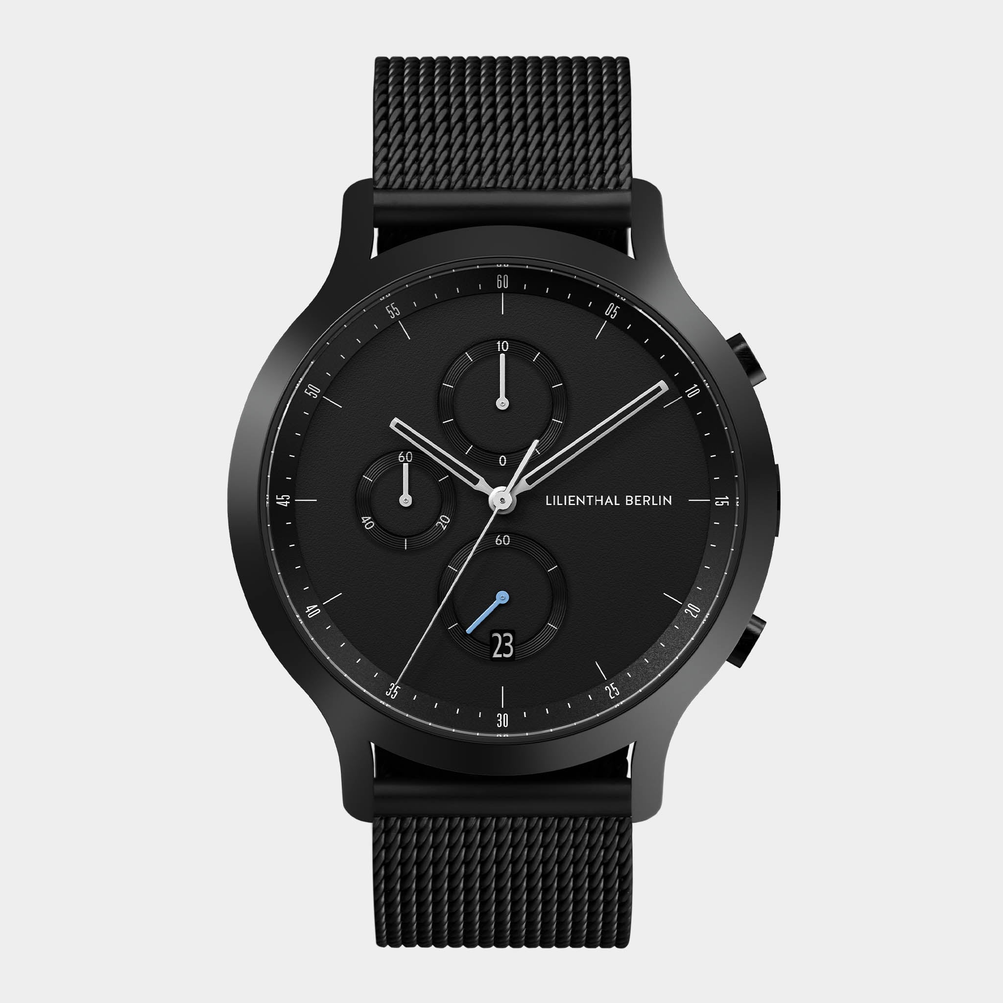 Black stainless steel chronograph watch with mesh strap and minimalist dial on white background