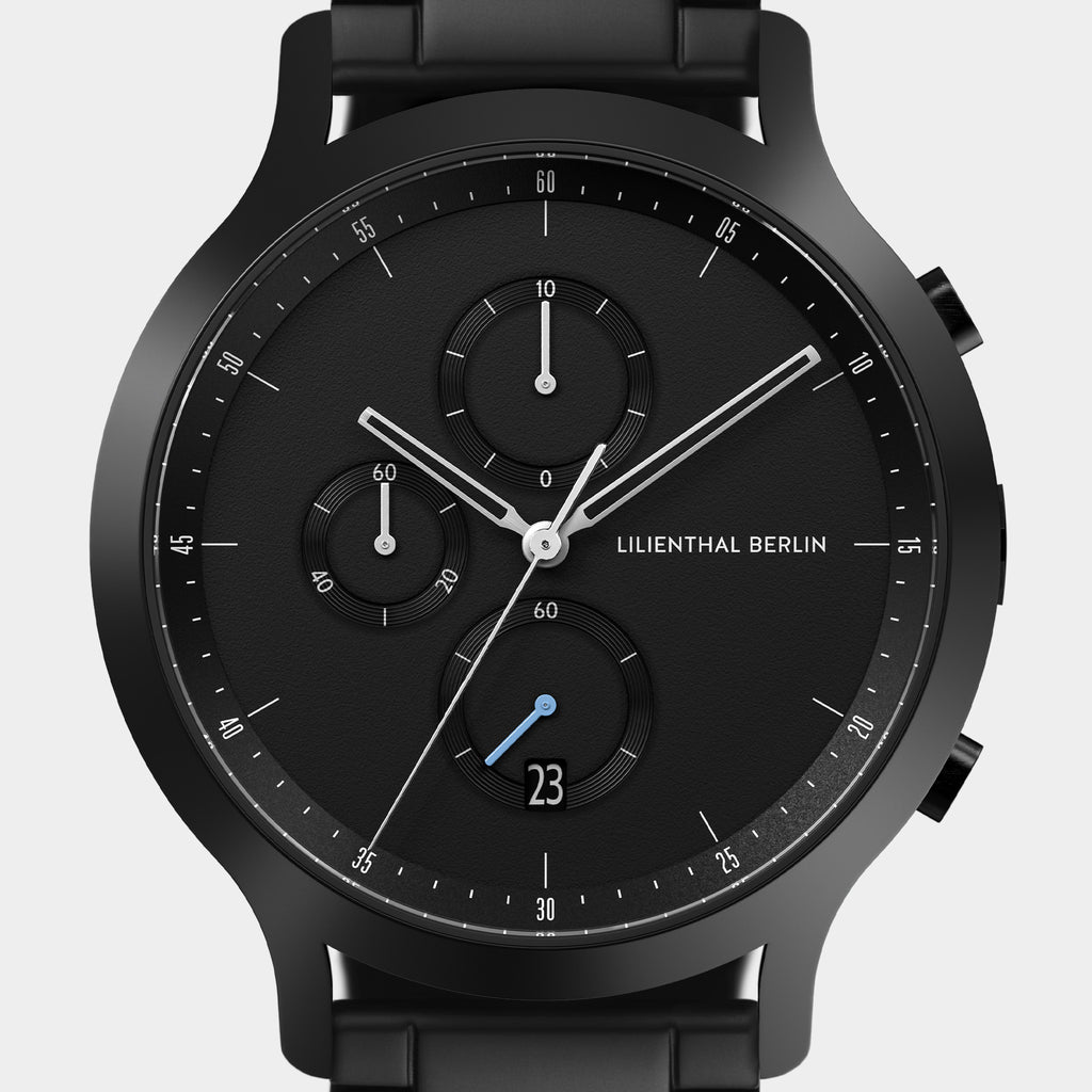 Close-up of a modern black chronograph wristwatch with subdials and date display
