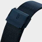 Black mesh stainless steel watch strap with engraved clasp on white background