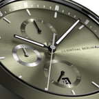 Close-up of a modern chronograph watch face with metallic olive dial and subdials