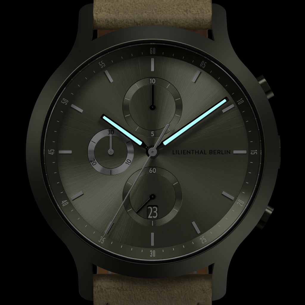 Modern chronograph watch with black case, brushed metal dial, and glowing blue hands