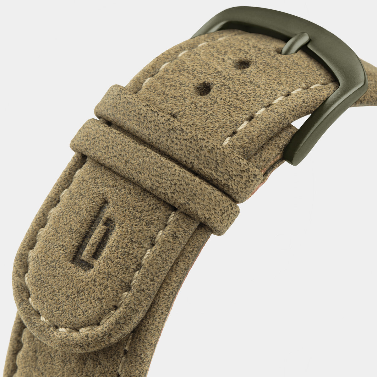 Textured beige suede watch strap with matte metal buckle and visible stitching, close-up.