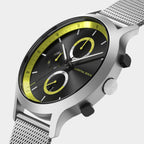 Modern silver mesh watch with black dial, yellow accents, and chronograph subdials
