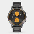 Modern chronograph watch with black metal band, black dial, and orange subdials.