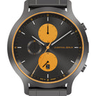 Modern chronograph watch with black dial, orange subdials, date display, and grey strap
