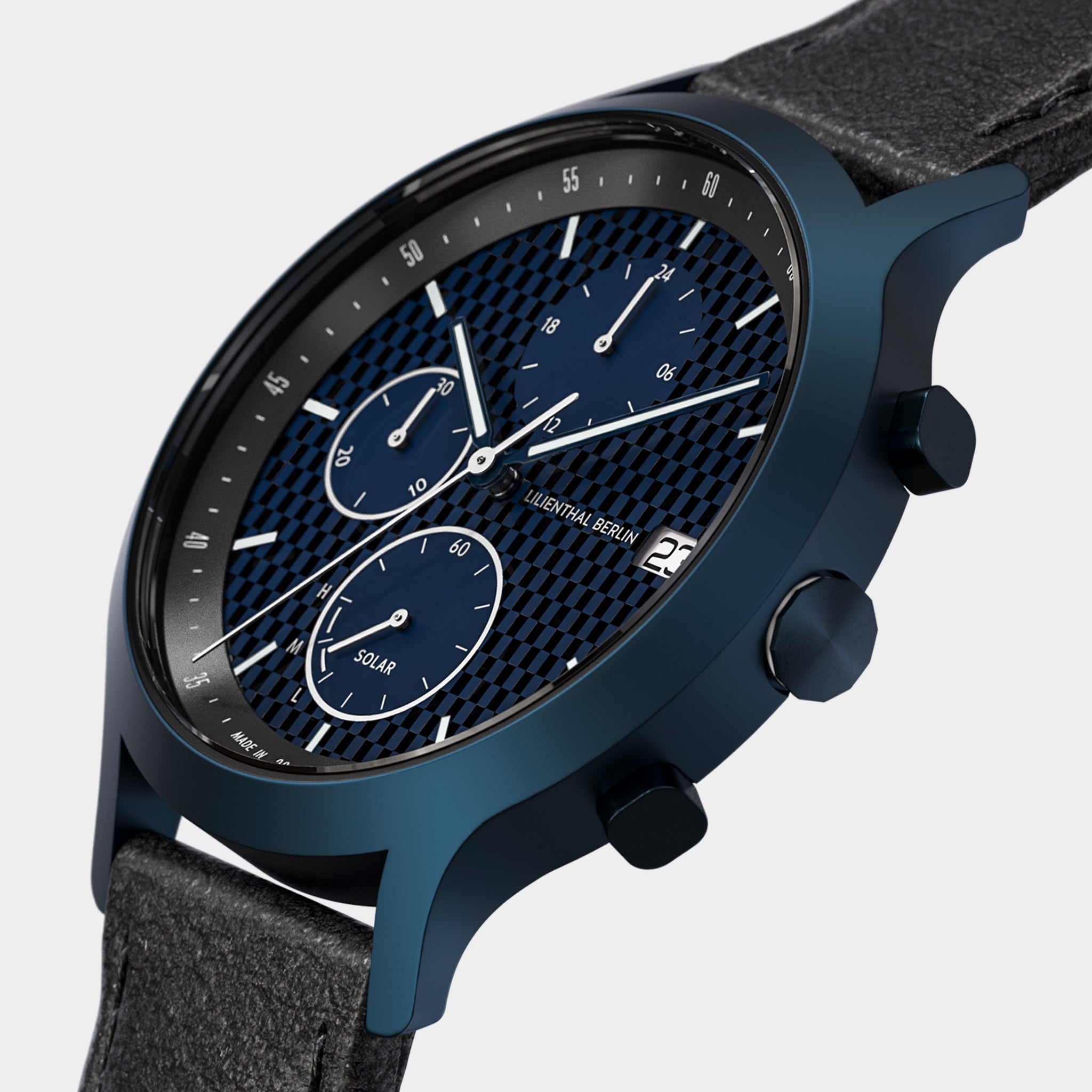 Blue chronograph solar watch with black textured dial and leather strap, close-up view