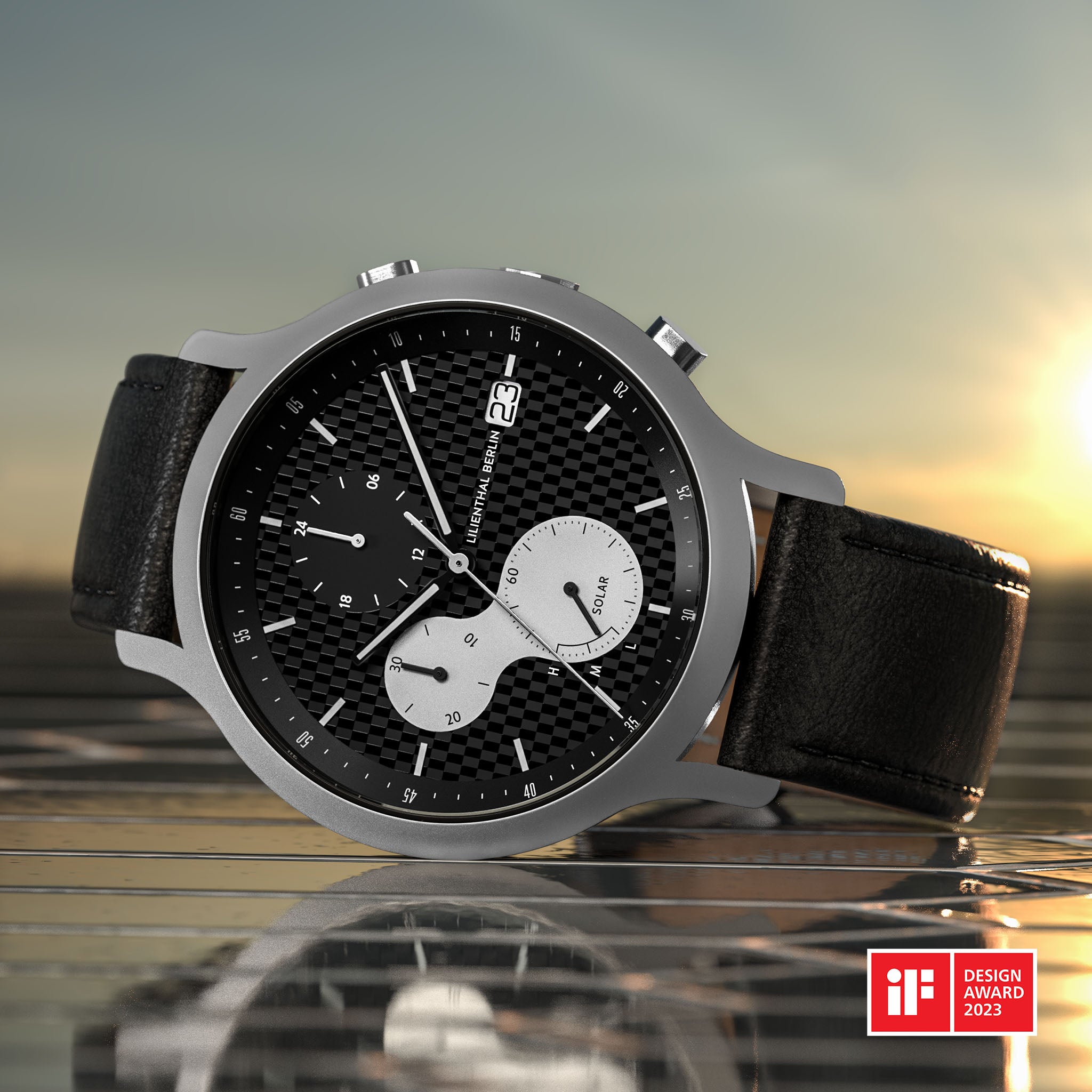 Modern solar chronograph watch with black textured dial, subdials, and leather strap at sunset.