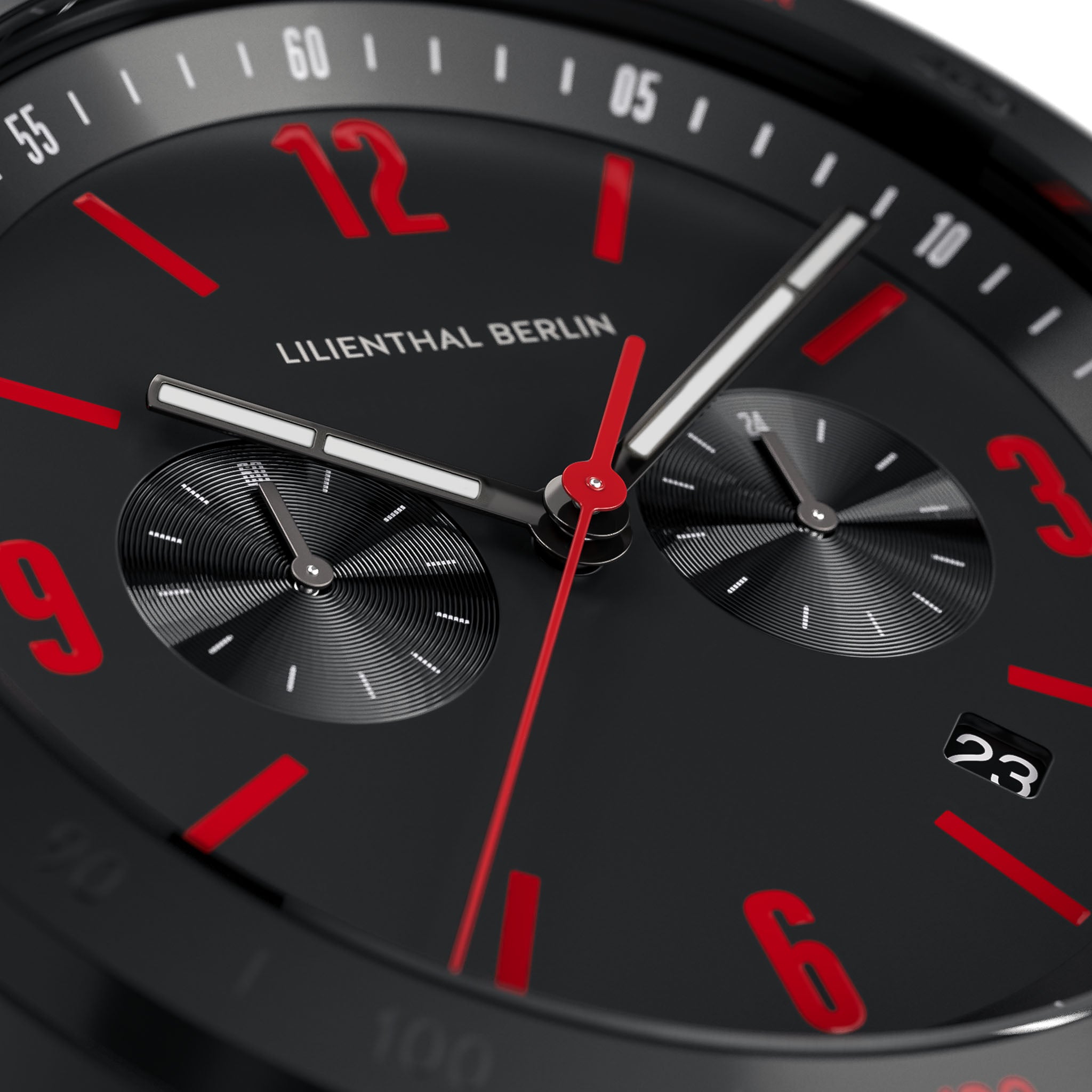 Close-up of black chronograph watch face with red numerals, date display, and subdials.