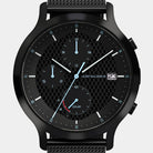 Black solar chronograph watch with mesh strap, checkerboard dial, and blue hands