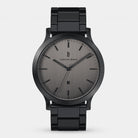 Minimalist black metal wristwatch with grey brushed dial and date display on white background