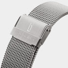Close-up of stainless steel mesh watch strap with engraved clasp on white background