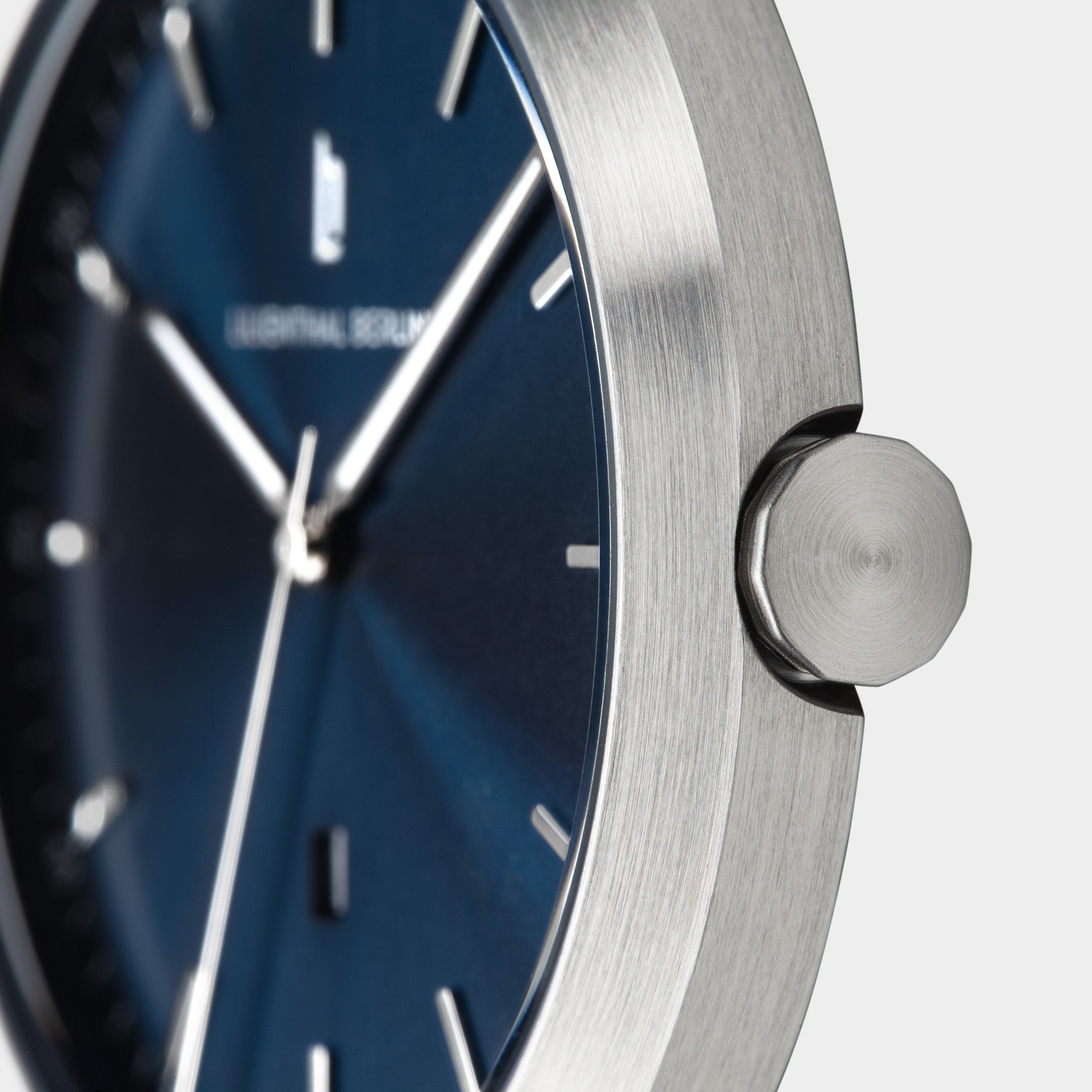 Close-up of minimalist wristwatch with brushed stainless steel case and blue dial