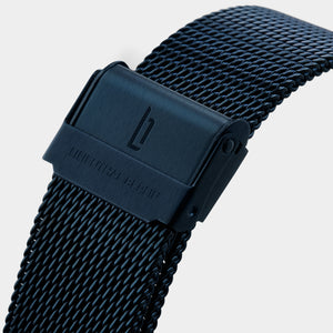 Black mesh stainless steel watch band with engraved clasp on white background
