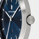 Close-up of minimalist silver watch with blue dial and silver hour markers