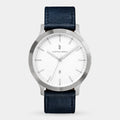 Minimalist silver wristwatch with white dial, date display, and black leather strap