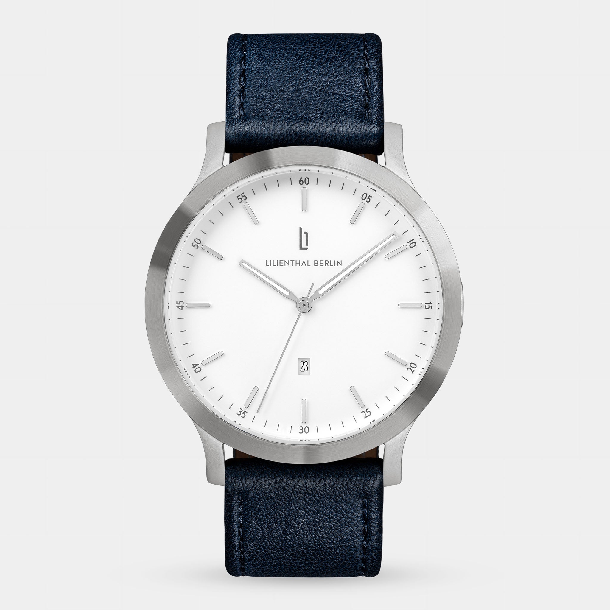 Minimalist silver wristwatch with white dial, date display, and black leather strap