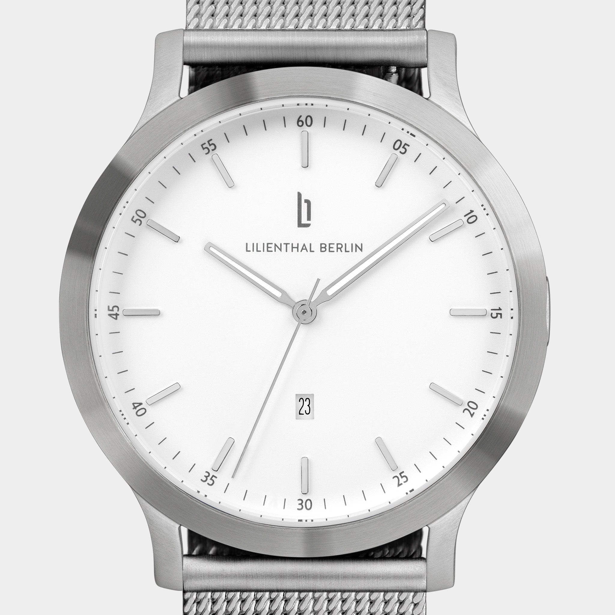 Minimalist silver wristwatch with white dial, mesh band, and date display