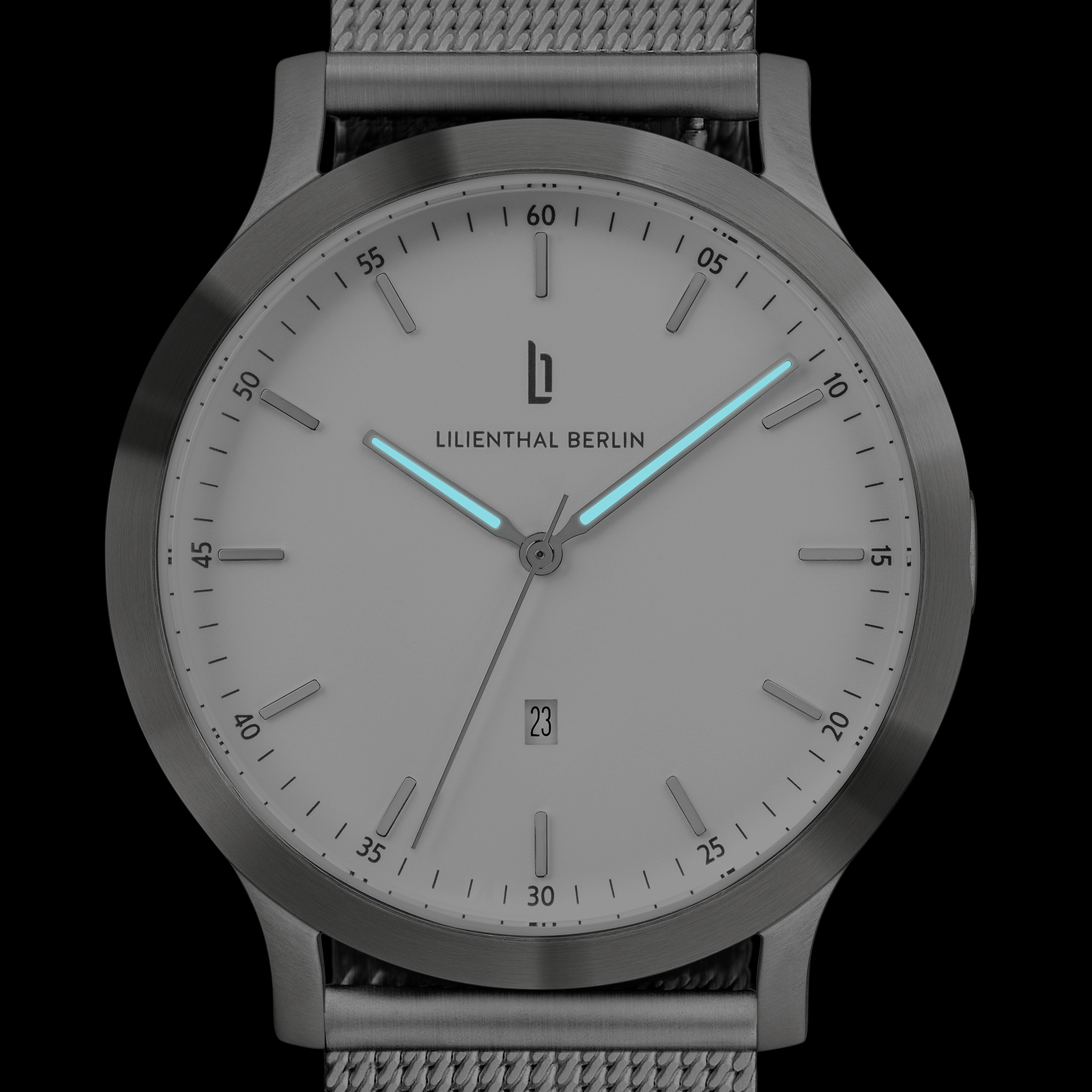 Minimalist silver watch with gray mesh strap, luminous blue hands, and date display