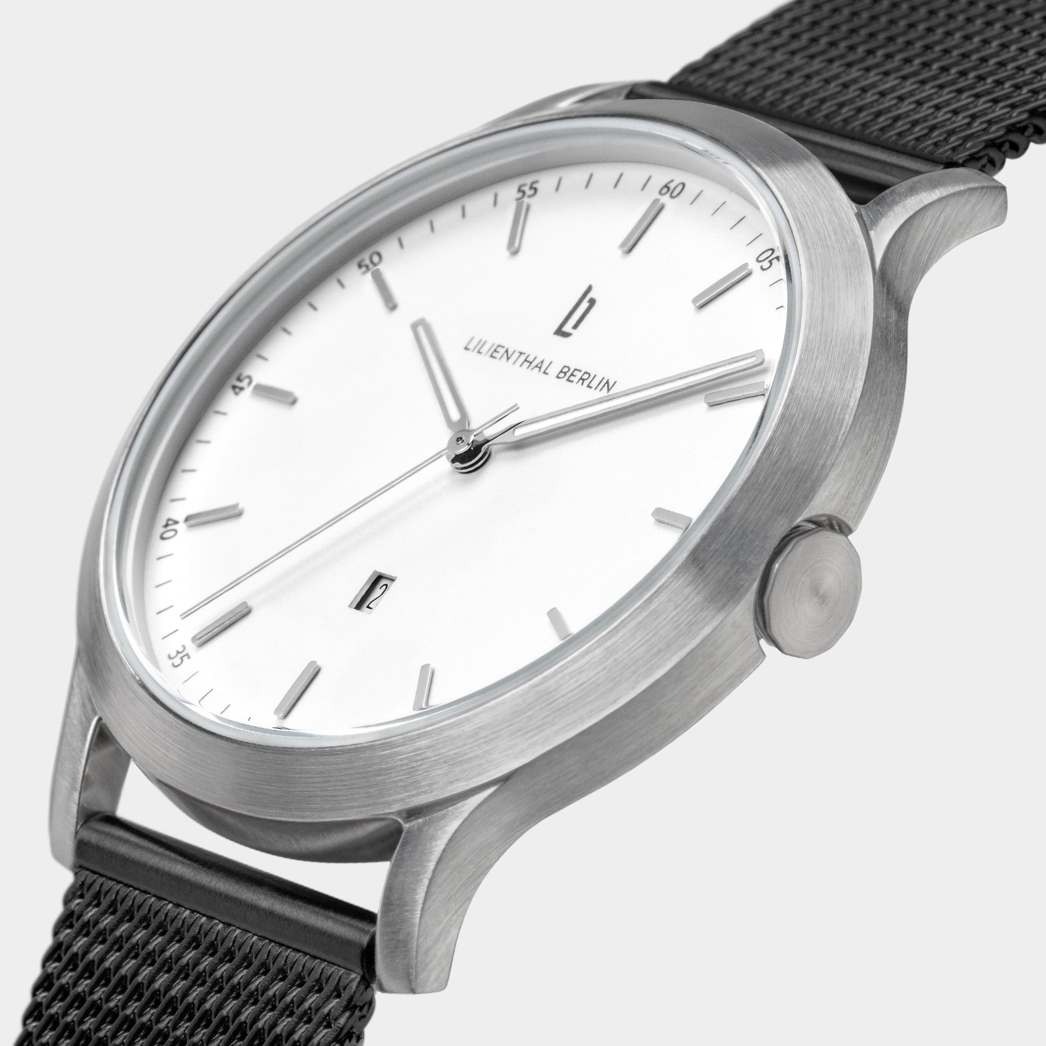 Minimalist silver wristwatch with white dial and black mesh strap, close-up view