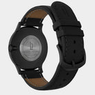 Back view of a black stainless steel watch with Huxley engraving and black leather strap