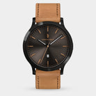 Men's analog wristwatch with black sunburst dial, gold markers, date display, and brown leather strap