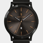 Black mesh band watch with dark sunray dial, gold indices, and date display at six o'clock